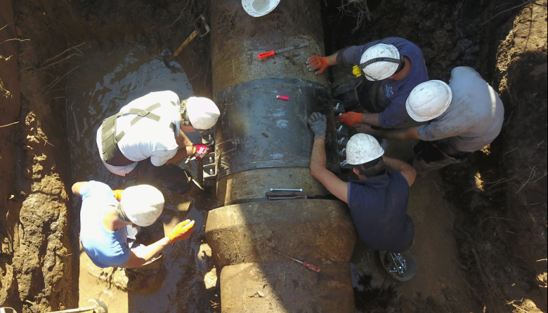 Personal de la empresa ABSA trabaja sobre una cañería de agua en Punta Lara